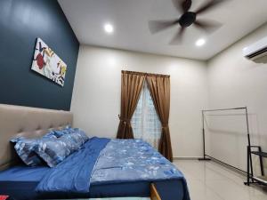 a bedroom with a blue bed and a ceiling fan at D'Kampung Homestay Melaka in Melaka