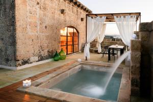 bañera en el medio de una habitación con en Dimora Sighé, esclusiva villa di design con piscina privata idromassaggio in Puglia, en Alessano