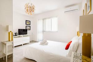 Habitación blanca con cama y TV en Casa Leon Malta en St Julian's
