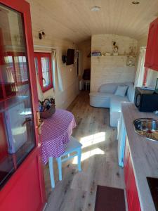 uma cozinha e sala de estar numa pequena casa em Margaux B&B Babbita em Stokrooie