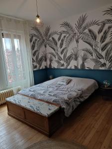 a bedroom with a bed and a wall mural at L'Echappée Belle in Chartres