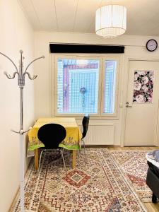 a room with a table and chairs and a window at two bedrooms,dining area and bathroom with private entrance in Kotka