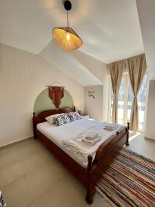 Un dormitorio con una cama grande y una lámpara de araña. en Villa Merci Budva en Budva