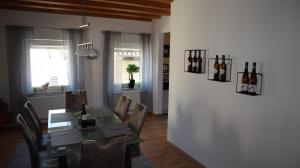 jadalnia ze stołem i butelkami wina na ścianie w obiekcie Toskana w mieście Klingenmünster