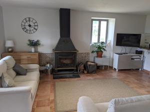 a living room with a couch and a fireplace at Gite de Fleurie - Tursac in Tursac