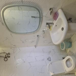 a white bathroom with a sink and a mirror at فيلا ميسرة الهدا in Al Hada