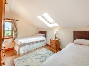 a bedroom with two beds and a skylight at The Old Dairy in Clay Cross