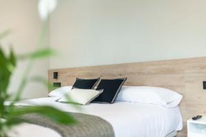 a white bed with black and white pillows at Albatros in Puentedeume