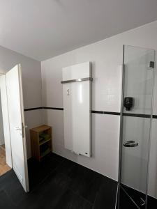 a bathroom with a shower and a refrigerator at Ferienwohnung Coburger Land, ländlich gut gelegen in Meeder