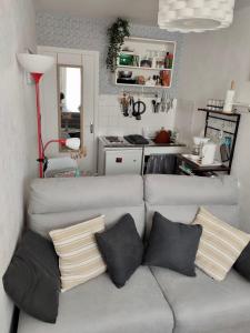 sala de estar con sofá y almohadas en Le Cocon de Neptune en Arromanches-les-Bains