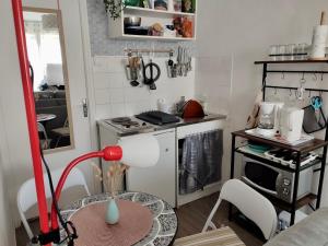 eine kleine Küche mit einem Tisch und einem Herd in der Unterkunft Le Cocon de Neptune in Arromanches-les-Bains