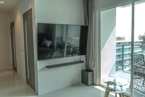 a living room with a glass table and a large window at Mae Phim Grand Blue Condo 508 with pool and seaview in Mae Pim