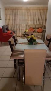 a dining room with a table and chairs and a couch at Lihle's Paradise in Margate