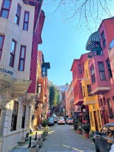 uma rua da cidade com edifícios coloridos e carros nela em Kuzguncuk View em Istambul
