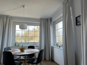 ein Esszimmer mit einem Tisch, Stühlen und einem Fenster in der Unterkunft Fi-Eck Apartments in Waldeck