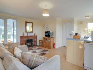 a living room with a couch and a fireplace at Curlew Cottage in Thorpe Saint Peter
