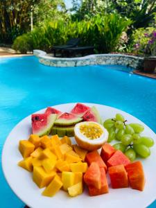 a plate of fruit on a table next to a pool at Whispering House in Tangalle
