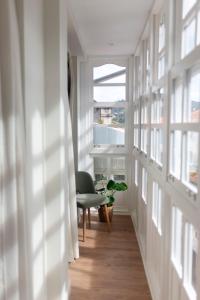 um corredor com uma cadeira e uma janela em Albatros em Puentedeume