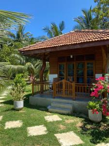 una pequeña casa con porche y algunas plantas en Hanguk Lanka Lagoon Villa en Tangalle