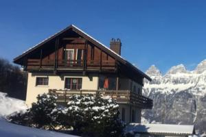 een huis in de sneeuw voor een berg bij Wohnung in Bergchalet in Flums