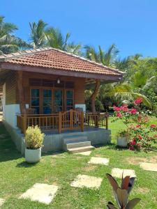 una pequeña casa con porche y algunas flores en Hanguk Lanka Lagoon Villa en Tangalle