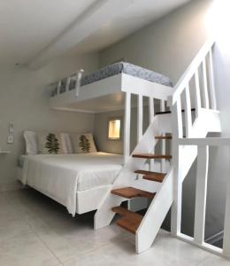 1 dormitorio con litera blanca y escalera en Studio Apartamento Lindo na Rua das Pedras, en Búzios