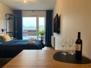 a living room with a bottle of wine and two wine glasses at PM. Apartments Krakow in Krakow