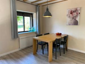 une salle à manger avec une table et des chaises en bois dans l'établissement Sfeervol vakantiehuis op landgoed aan de Dordogne, à Prudhomat