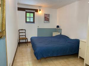 une chambre avec un lit bleu et une chaise dans l'établissement Sfeervol vakantiehuis op landgoed aan de Dordogne, à Prudhomat