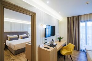um quarto de hotel com uma cama, uma secretária e uma cadeira em Gloria Palace Hotel & SPA em Golem
