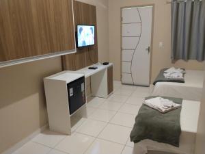a room with two beds and a flat screen tv at Pousada Rota das Dunas de Amaro in Santo Amaro