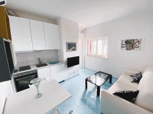 Sala de estar blanca con sofá y mesa en VIP View & Exclusive Access to the Sea, en Porto Santo Stefano