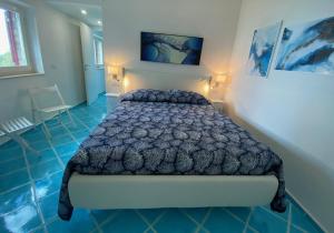 a bedroom with a bed in a room with blue floors at VIP View & Exclusive Access to the Sea in Porto Santo Stefano