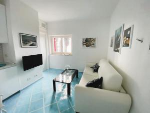 sala de estar con sofá y TV en VIP View & Exclusive Access to the Sea en Porto Santo Stefano