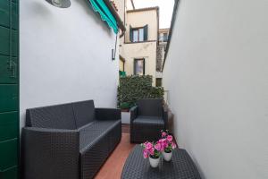 a small balcony with black chairs and flowers at B&B Da Nina Venice in Venice