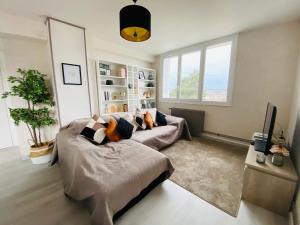 a living room with a couch and a tv at Superbe appartement centre Montluçon, proche hôpital in Montluçon