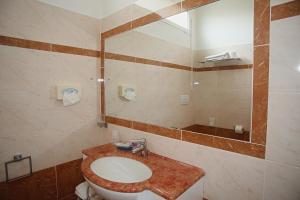 bagno con lavandino e specchio di Hotel Dear Rimini a Rimini