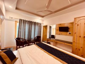 a hotel room with a bed and a desk at Royal View Inn in Manāli