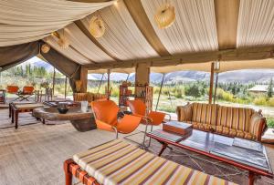 a living room with couches and chairs in a tent at Chamba Camp Diskit by TUTC in Nubra