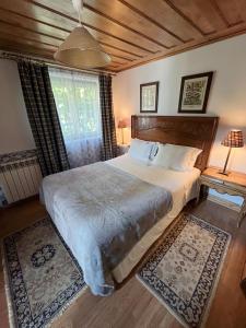 a bedroom with a large bed with a wooden headboard at Casa De Canilhas in Mesão Frio