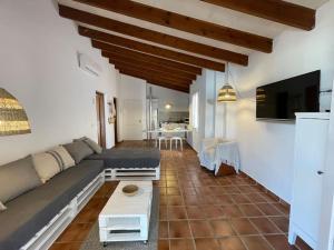 ein Wohnzimmer mit einem Sofa und einem TV in der Unterkunft Sa Calma 47 in Son Xoriguer