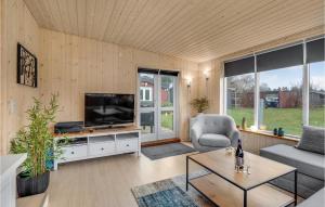 a living room with a tv and a couch and a table at 1 Bedroom Nice Home In Højby in Højby