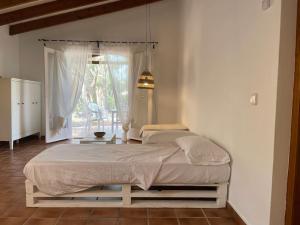 ein großes Bett in einem Zimmer mit Fenster in der Unterkunft Sa Calma 47 in Son Xoriguer