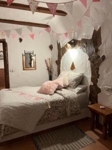 1 dormitorio con cama, mesa y banderas en Cuevas de la Paz - Cave House Holidays, en Los Carriones