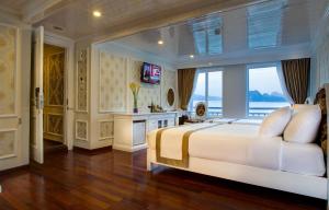 Un dormitorio con una gran cama blanca y una ventana en Signature Royal Halong Cruise, en Ha Long