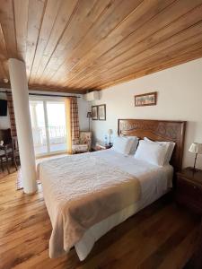 Casa De Canilhas في ميساو فريو: غرفة نوم بسرير كبير بسقف خشبي
