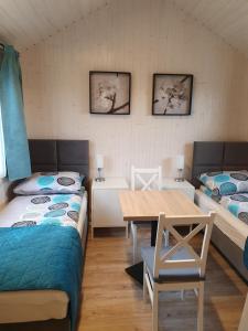 um quarto com duas camas e uma mesa em Pokoje Babie Lato em Breslávia
