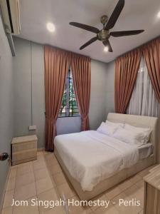 a bedroom with a bed and a ceiling fan at Jom Singgah Homestay - Perlis in Kangar