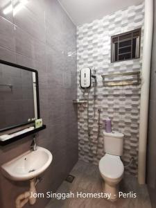 a bathroom with a white toilet and a sink at Jom Singgah Homestay - Perlis in Kangar