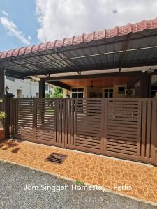 a wooden fence in front of a house at Jom Singgah Homestay - Perlis in Kangar